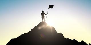 Empowered individual standing on a mountain peak with a flag, symbolizing personal growth and achievement.